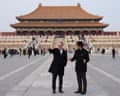 Starmer points as a man stands alongside speaking to him, with a Forbidden City building behind
