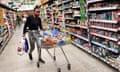 A shopper pushes a trolley at a supermarket in London