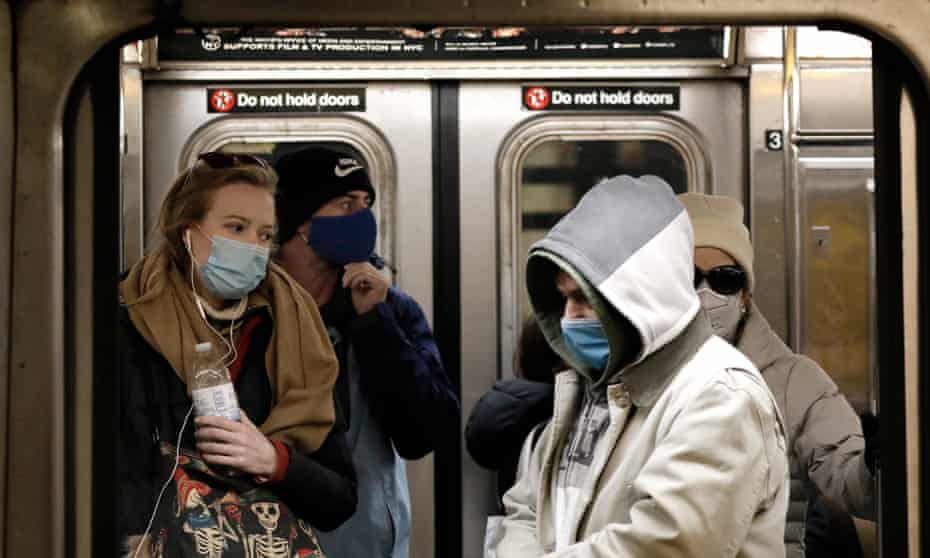New York subway riders wearing masks. Fourteen states and Washington DC have universal masking policies.
