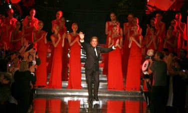 Valentino waves from the stage surrounded by models all wearing red dresses