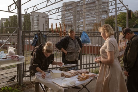 People stand at a market stall