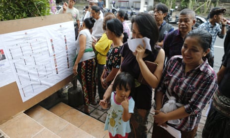 People queue up before the start of voting during presidential and legislative elections in Bali, Indonesia