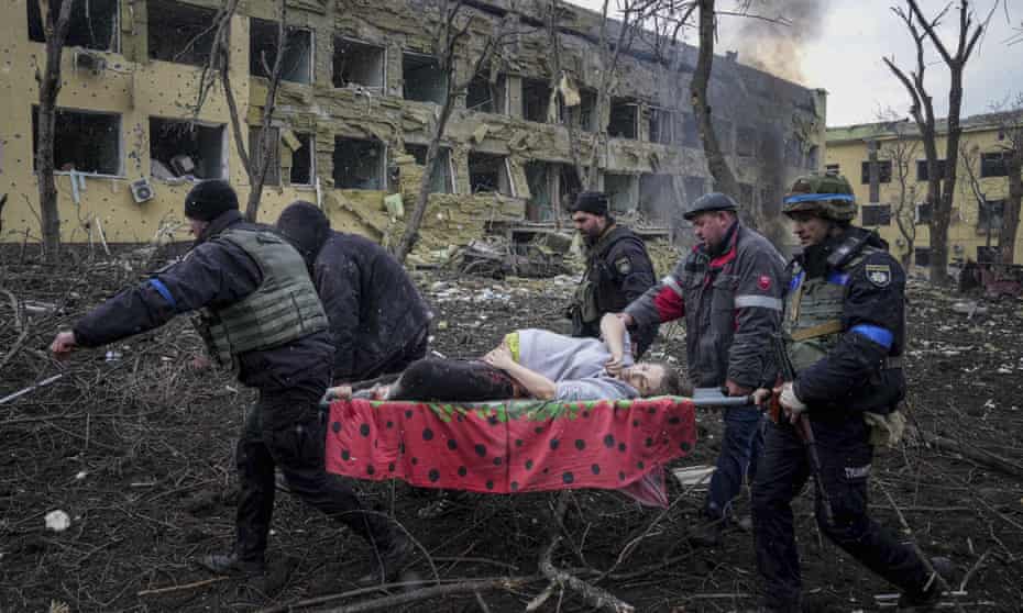 Ukrainian emergency employees and volunteers carry an injured pregnant woman from the damaged by shelling maternity hospital in Mariupol