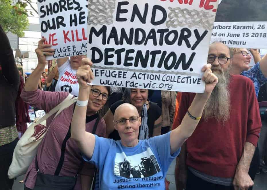 Christina Coombe, who died in May 2019, at a rally holding a sign asking for an end to mandatory detention.