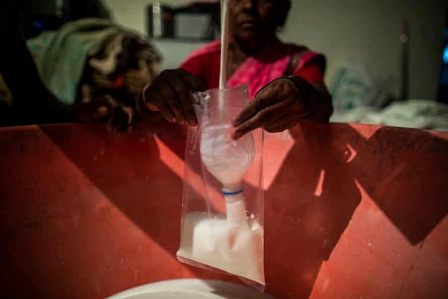 Nitin Bedjawalge, 25, with his wife Susma, 21, and his mother Kusum, 55, fill and seal 250 packets of milk at a Lakshmi Dairy, from 3.30am, to be delivered in the nearest town of Latur by 6am, Davatpur, Latur District, Maharashtra