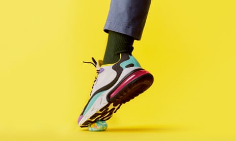 Foot in trainer crushing a globe, against yellow background
