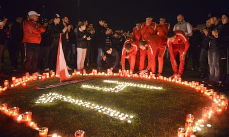 Dinamo Bucharest players light candles along with supporters for team-mate Patrick Ekeng, who died after collapsing during a league match on Friday.