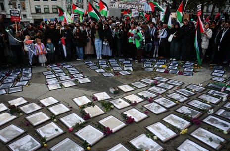 Protesters hold Palestinian flags next to photographs of dead Palestinian children laid out at Trafalgar Square during a ‘Ceasefire Now’ rally in London, Britain, 04 November 2023, calling for a ceasefire in Gaza.