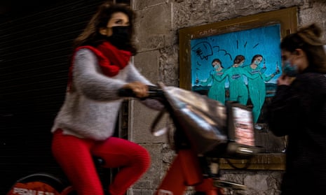 Commuters pass a mural by Italian urban artist TVBoy, Salvatore Benintende, called the ‘Three Vaccines’ in reference to 15th-century oil painting ‘Three Graces’ by Italian painter Raphael, depicting three figures holding covid-vaccines from ‘moderna’, ‘Pfizer’ and ‘AstraZeneca’ in Barcelona, Spain.