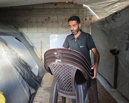 Ahmed Ishtaiwi carries his chairs