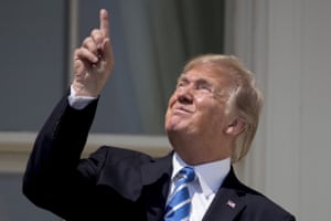 Donald Trump points to the sun as he arrives to view the solar eclipse at the White House.