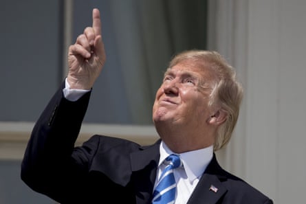In this Aug. 21, 2017, file photo, President Donald Trump points to the sun as he arrives to view the solar eclipse at the White House in Washington.