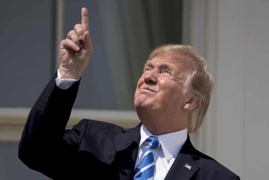 Donald Trump points to the sun as he arrives to view the solar eclipse at the White House.