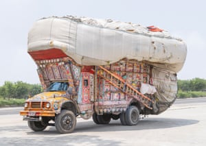 A large truck with bright, colourful patterns, carrying a large sack