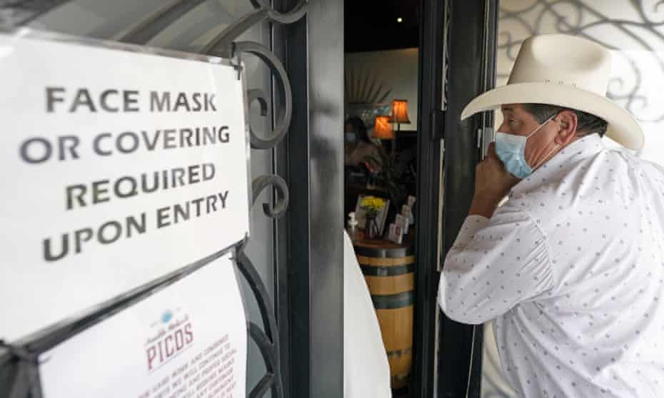 Sergio Almaguer wears a mask as he enters a restaurant in Houston. Texas has dropped its mask mandate, but many businesses continue to require them. 