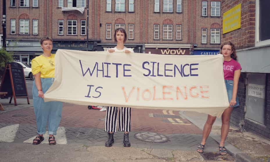 Meghann Foster, Katherine Plumb and Anna Gretton hold the banner outside their flat in Crouch End