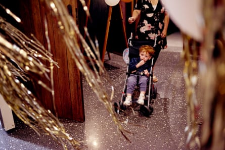 Toddler sitting in a pram amongst streamers