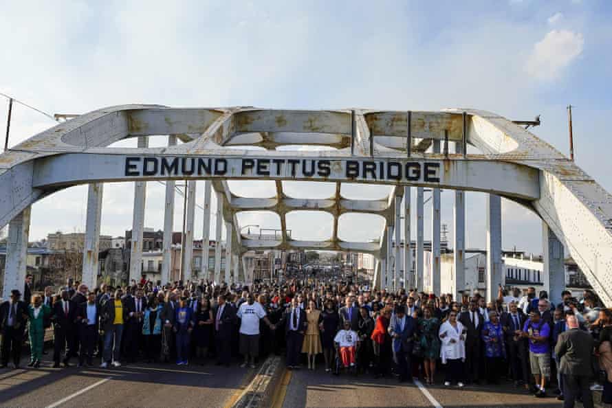 Kamala Harris links arms with marchers on the Edmund Pettus Bridge on Sunday.