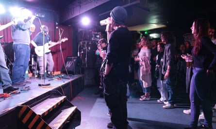 People stand watching a band onstage
