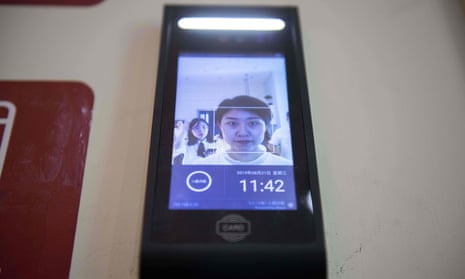 A woman uses a facial recognition device installed at an IFuree Go self-service supermarket in Tianjin