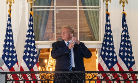 Donald Trump takes off his mask after returning to the White House on 5 October last year, following several days in hospital with Covid.