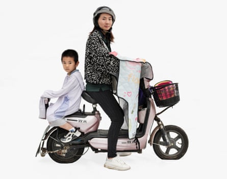 Housewife Zu‘en and her son Naige riding a Shuanghe in Shanghai, China. It is a scooter and her son is sitting facing backwards on the back