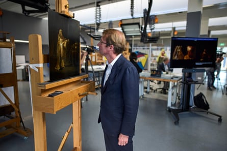 Taco Dibbits looks closely at the painting in a Rijksmuseum studio