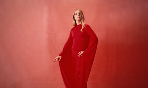 Chelsea Manning in red dress against orange background, photographed in Brooklyn, New York, October 2022