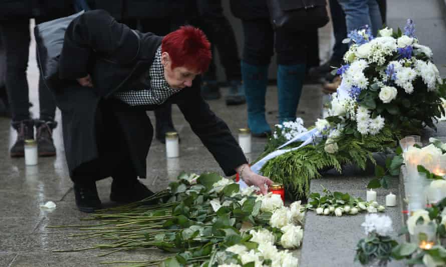 A mourner lays a candle at a memorial to victims of the attack.
