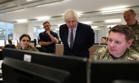 Boris Johnson watches operators behind monitors at the British Armed Forces' Northwood headquarters.