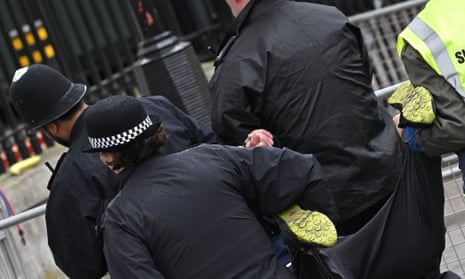 Police officers remove a protester during Saturday’s coronation proceedings