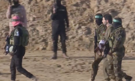 Ofer Kalderon, second right, is led by militants during his release in Khan Younis
