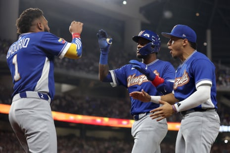 Maikel Garcia of Venezuela celebrates with teammates after hitting a sacrifice fly against the United States during the third inning.