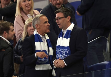 Mark Carney and Andy Burnham wearing Everton scarves at a football match