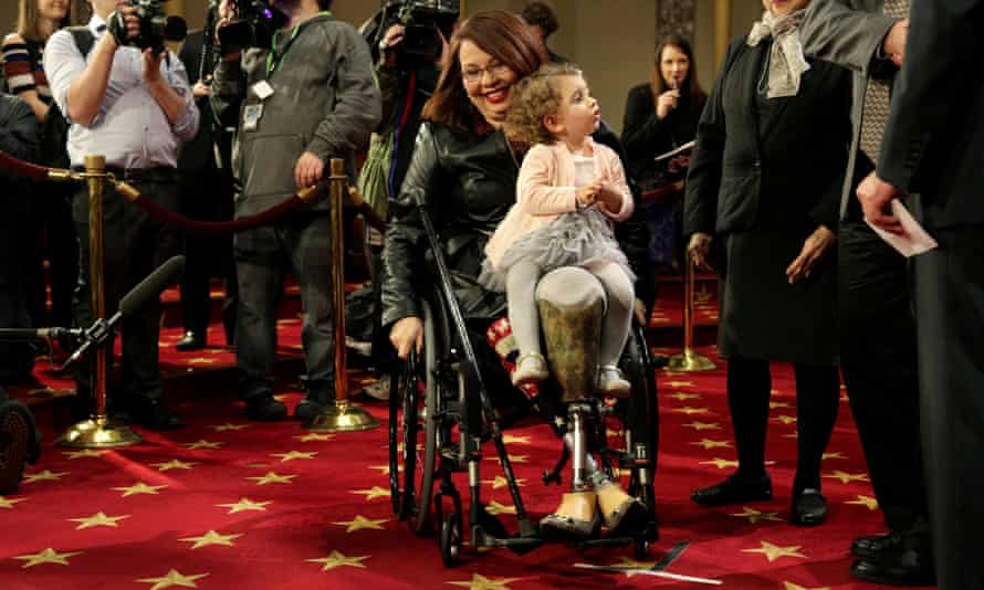 Duckworth carries her daughter Abigail during a mock swearing in with Vice President Joe Biden on Capitol Hill in 2017.