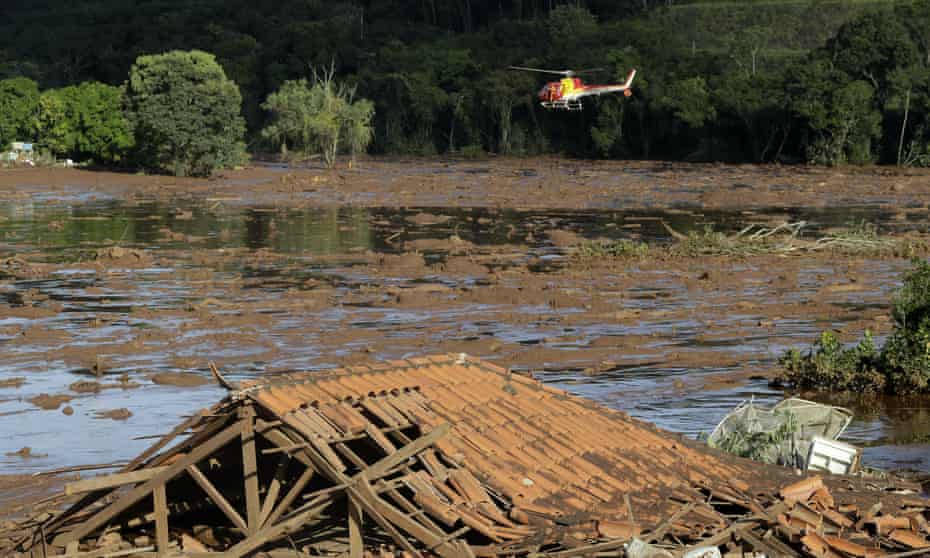 Rescue workers in a helicopter search a flooded area after a dam collapsed in Brumadinho, Brazil, on 27 January 2019.