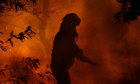 A firefighter works as a wildfire burns parts of rural areas in Quillón, Chile, on Thursday.