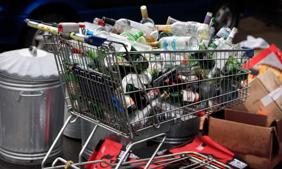 A supermarket trolley full of empty drinks bottles and cans awaiting