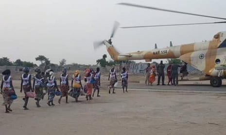 Some of the freed schoolgirls board a helicopter.
