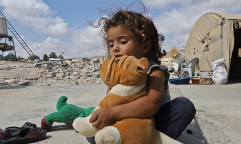 Zaynab Mohammed Ayoub plays next to the rubble of her demolished home.