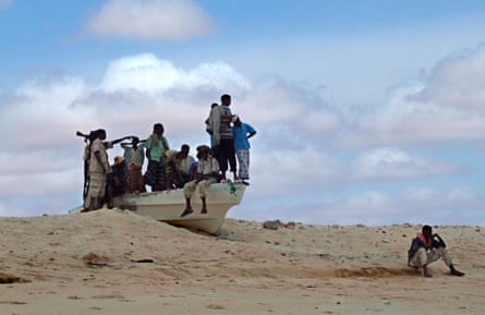 Armed Somali pirates guard the beach in a small speed boat in Hobyo district