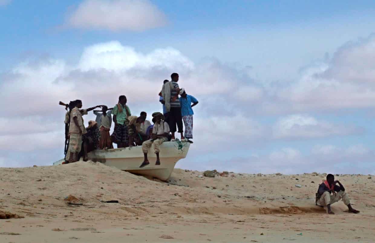 Armed Somali pirates guard the beach in a small speed boat in Hobyo district