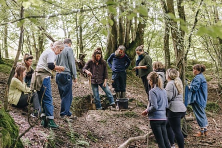 About a dozen people digging in the woods