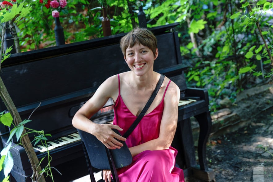 Architect and illustrator Natalia Shulga sits beside a piano in Lada Garden.