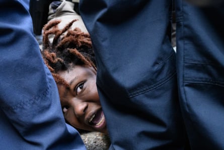 woman’s face in distress viewed between legs of police