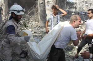Syrian civil defence workers remove a corpse from the debris after a regime air raid in the al-Kalaseh neighbourhood
