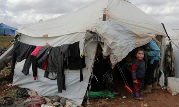 A displaced Syrian child from Idlib, stands outside a tent in Azaz, Syria. The Syrian government’s assault has killed around 300 civilians since the start of the year and displaced a million people.