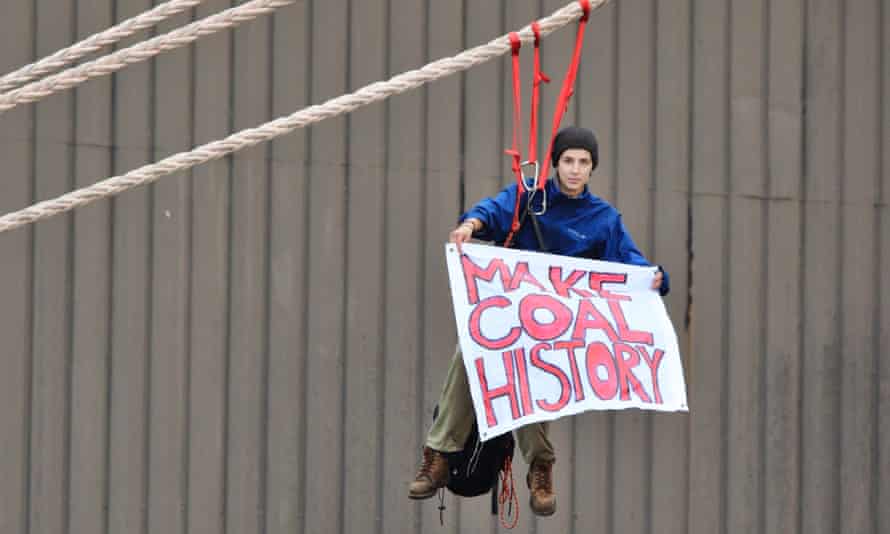 A protester hangs a banner from a coal ship docked in Newcastle harbour on Sunday.