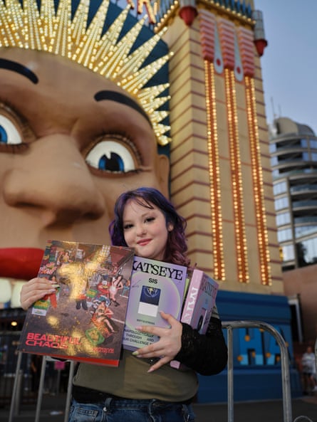 A girl holds band merchandise
