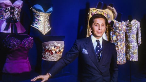 Valentino poses in front of some of his designs